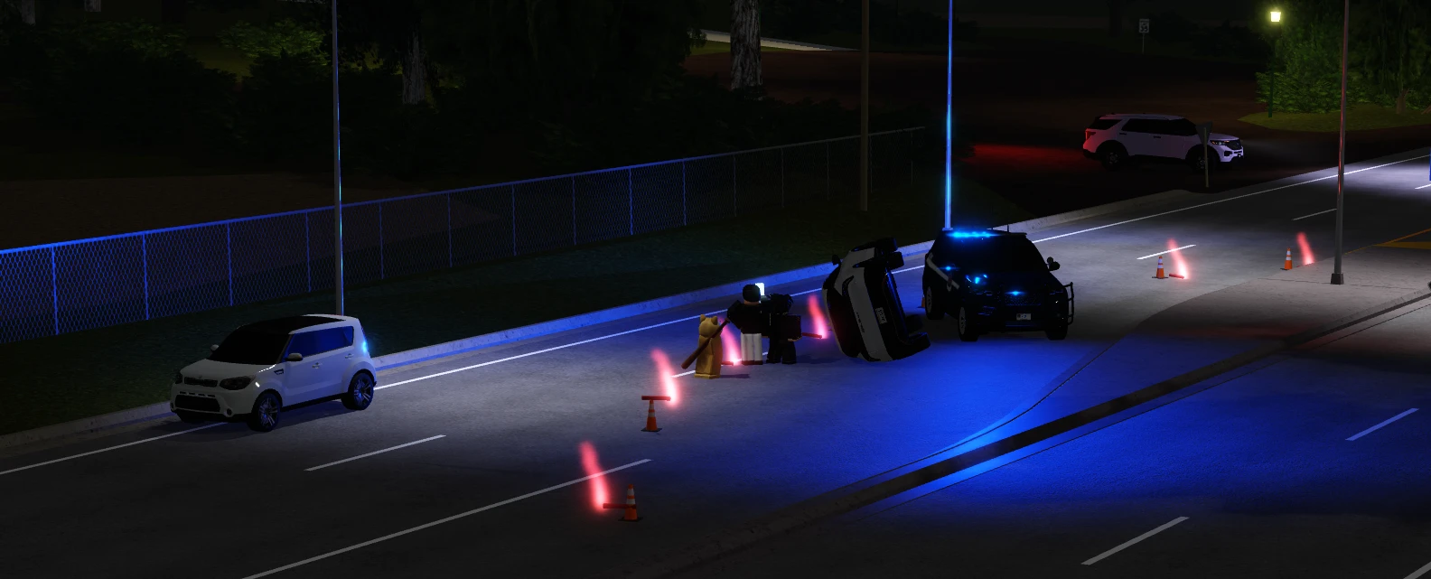 A WSP cruiser and officers working a rollover crash at night, with flares on the road.